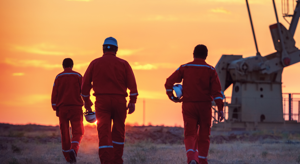 oil rig workers walking at sunset